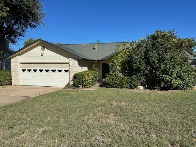 ranch-style home featuring a garage and a front lawn