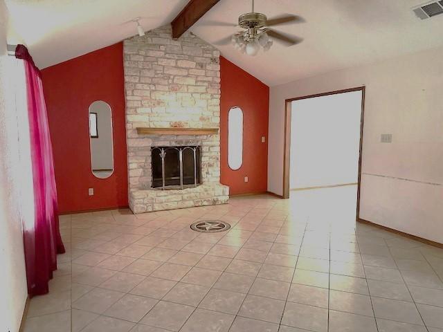 unfurnished living room featuring lofted ceiling with beams, ceiling fan, light tile patterned floors, and a fireplace