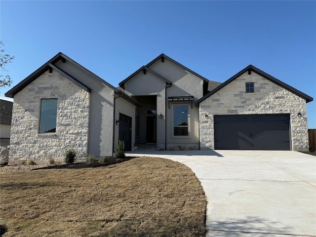 view of front of house featuring a garage, stone siding, concrete driveway, and stucco siding