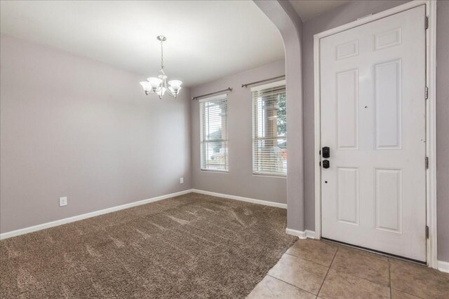 foyer featuring light tile patterned floors and a chandelier