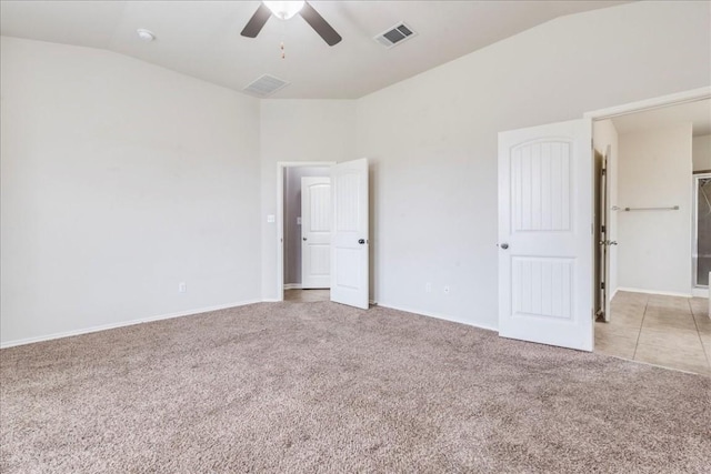 unfurnished bedroom with light colored carpet, vaulted ceiling, and ceiling fan