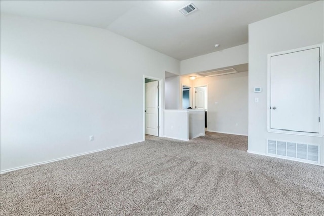 carpeted spare room featuring vaulted ceiling