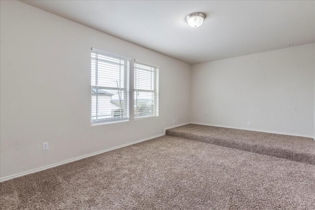 empty room with baseboards and carpet