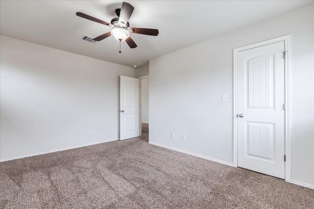 carpeted spare room with ceiling fan