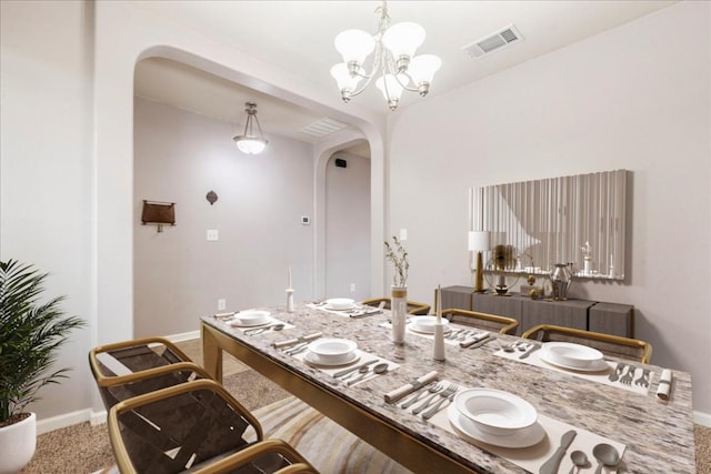 dining room with baseboards, an inviting chandelier, carpet flooring, visible vents, and arched walkways