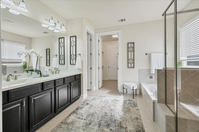 bathroom with tile patterned floors, vanity, a healthy amount of sunlight, and independent shower and bath