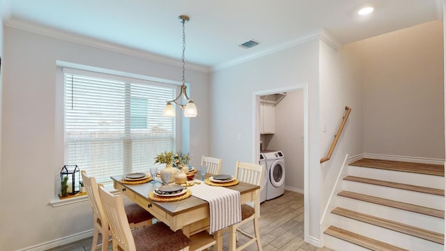 dining space featuring a notable chandelier, washer and dryer, crown molding, and light hardwood / wood-style flooring