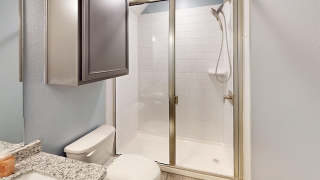 bathroom with vanity, an enclosed shower, and toilet