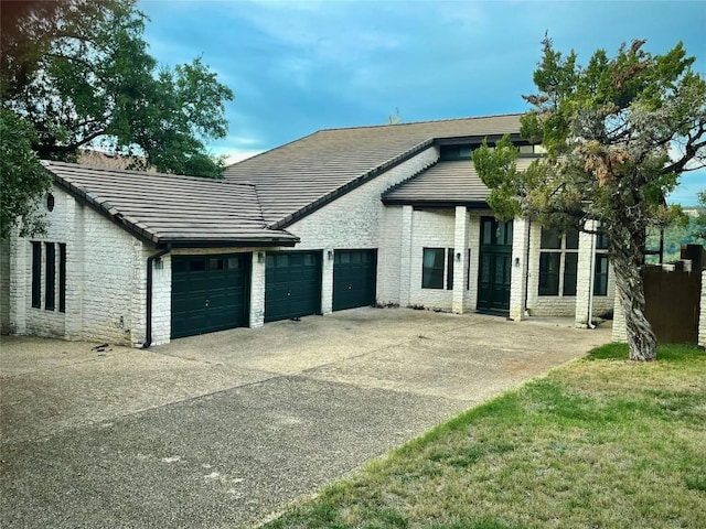 4324 Far W Blvd, Austin, TX 78731 - view of front of home with an attached garage, driveway, a tile roof, and stone siding
