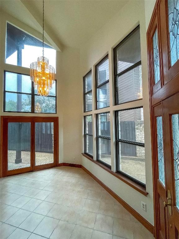 interior space featuring vaulted ceiling, a wealth of natural light, and a notable chandelier