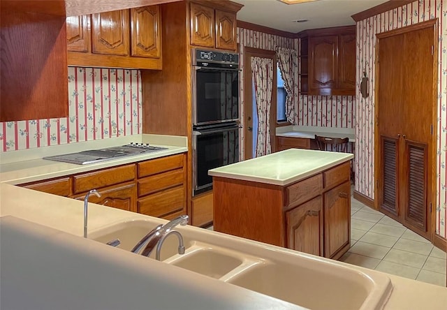 kitchen featuring light tile patterned floors, gas cooktop, black double oven, a center island, and sink