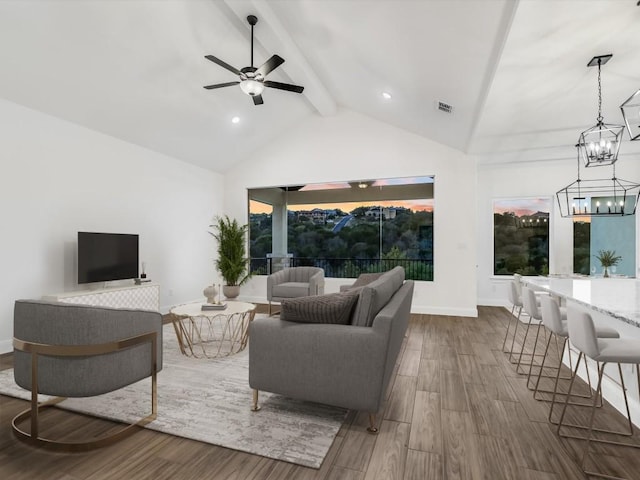 living room featuring beam ceiling, hardwood / wood-style flooring, a wealth of natural light, and ceiling fan