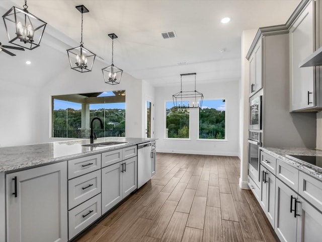 kitchen featuring decorative light fixtures, sink, and a wealth of natural light