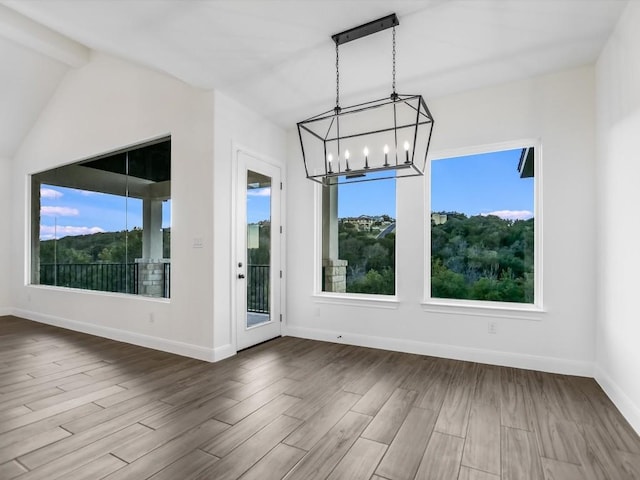 unfurnished dining area featuring a chandelier, wood-type flooring, and lofted ceiling with beams