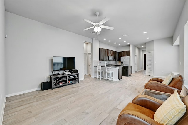 living room with light hardwood / wood-style flooring and ceiling fan