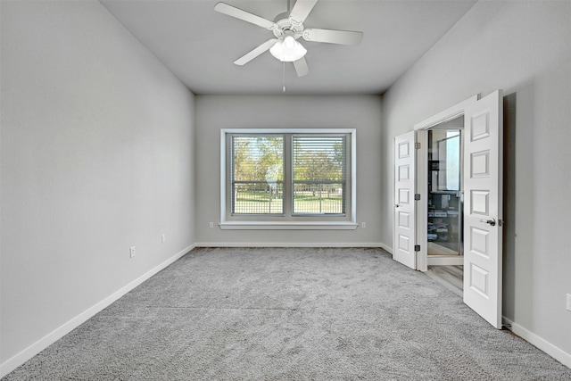 carpeted spare room with ceiling fan