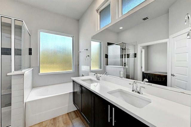 bathroom with vanity, hardwood / wood-style flooring, and shower with separate bathtub