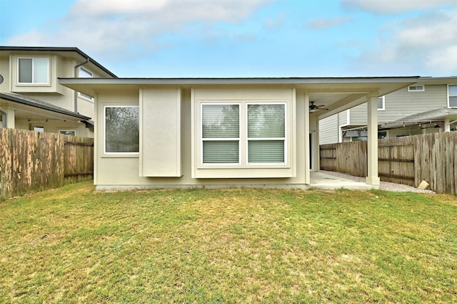 back of property featuring a yard and ceiling fan