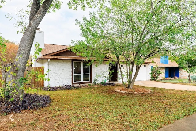 single story home with a front yard and a garage