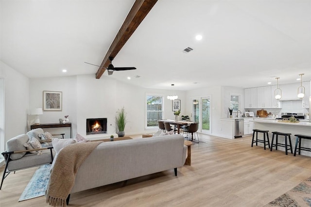 living room with vaulted ceiling with beams, light wood-type flooring, and ceiling fan