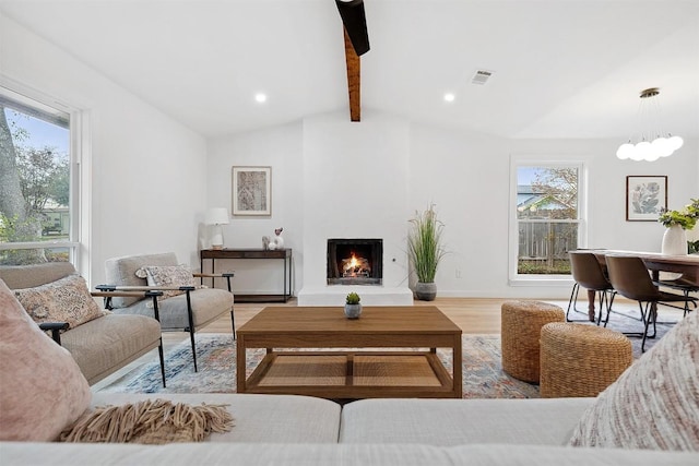 living room with a large fireplace, lofted ceiling with beams, and light wood-type flooring