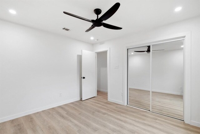 unfurnished bedroom with a closet, light hardwood / wood-style flooring, and ceiling fan