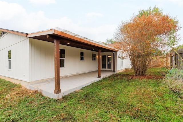 back of property featuring a patio area and a lawn