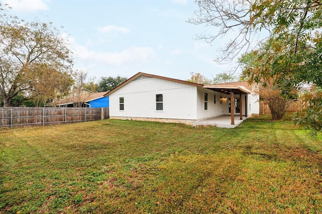 back of house featuring a patio and a lawn