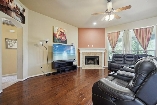 living room with ceiling fan, wood-type flooring, and a fireplace