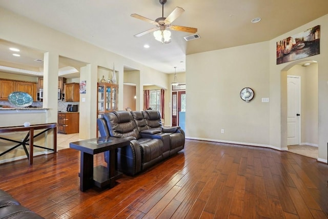 living room featuring ceiling fan and dark wood-type flooring