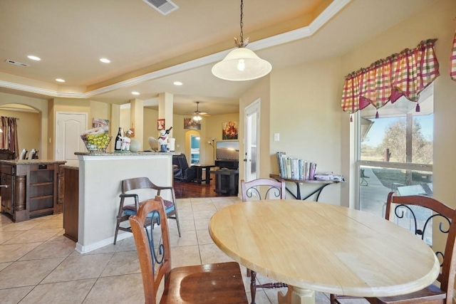 dining area featuring ceiling fan, light tile patterned flooring, and ornamental molding