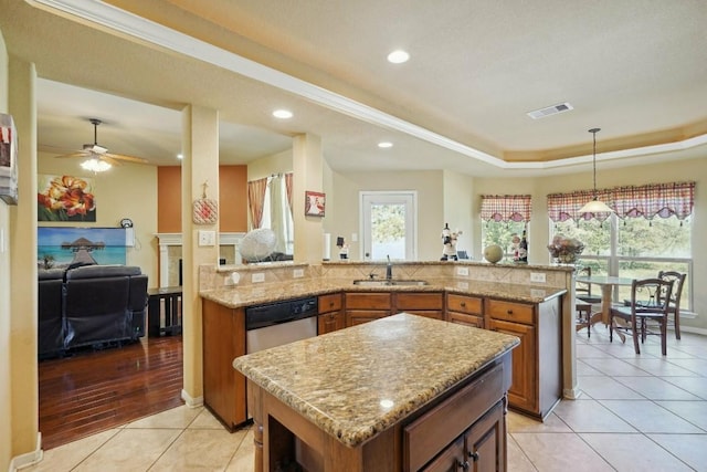 kitchen featuring ceiling fan, sink, hanging light fixtures, light hardwood / wood-style floors, and a kitchen island