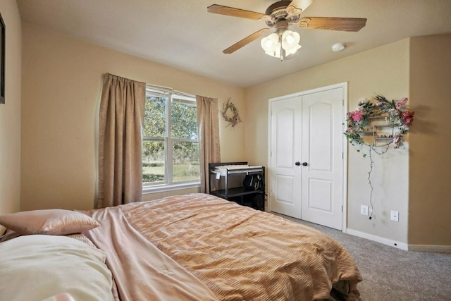 carpeted bedroom with ceiling fan and a closet