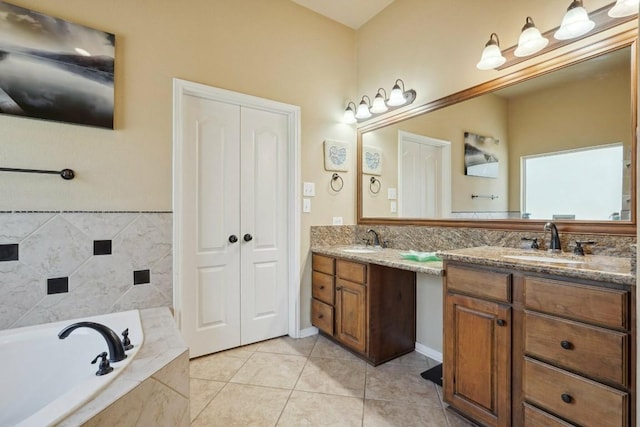 bathroom featuring tile patterned floors, vanity, and a relaxing tiled tub