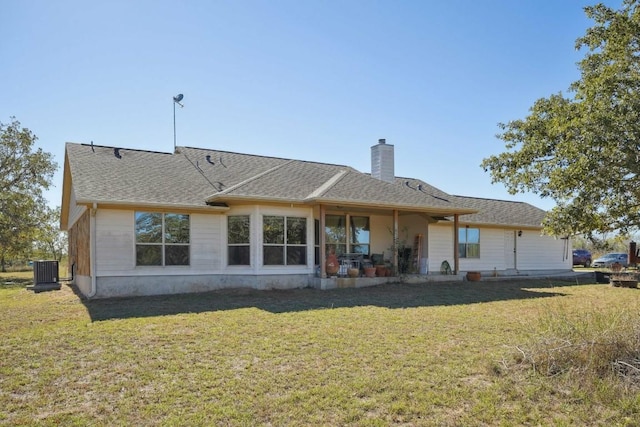 back of property featuring a lawn and central air condition unit