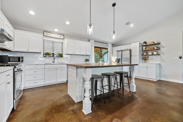 kitchen featuring white cabinets, stainless steel appliances, a kitchen island, and sink