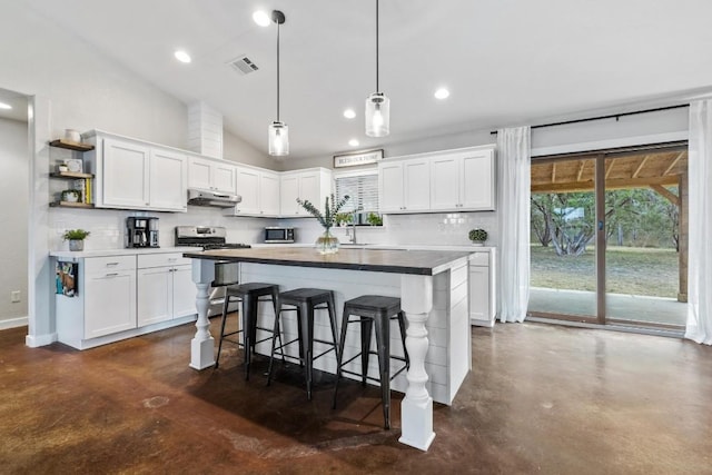 kitchen featuring white cabinetry, stainless steel appliances, and lofted ceiling