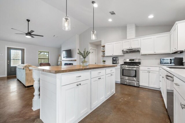 kitchen with appliances with stainless steel finishes, sink, white cabinets, a center island, and hanging light fixtures