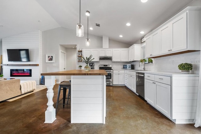 kitchen with a breakfast bar, a center island, hanging light fixtures, white cabinetry, and stainless steel appliances