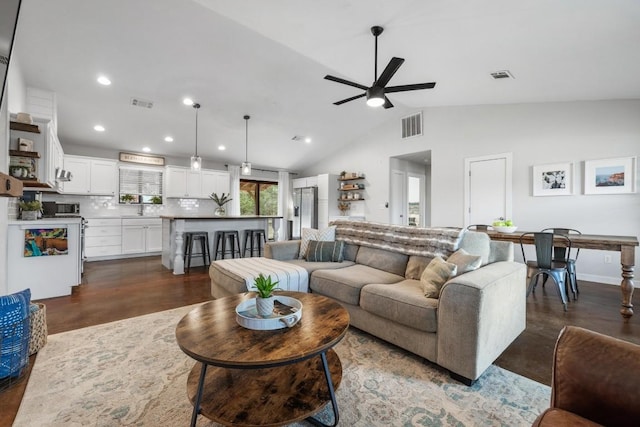 living room featuring vaulted ceiling, ceiling fan, dark wood-type flooring, and sink