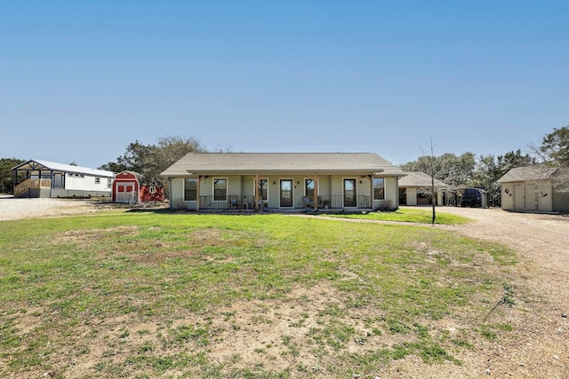 ranch-style home featuring a porch, a shed, and a front yard