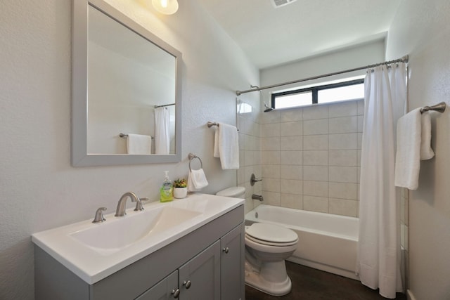 full bathroom with shower / tub combo with curtain, vanity, and toilet