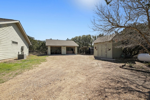 exterior space featuring a storage shed, central air condition unit, and a carport