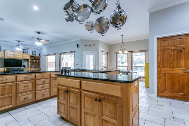 kitchen featuring a kitchen island, ornamental molding, sink, and hanging light fixtures