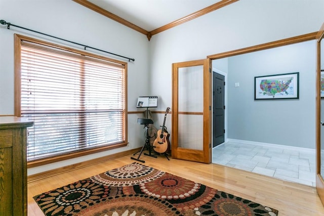 foyer entrance featuring french doors, crown molding, and light hardwood / wood-style flooring