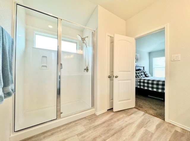 bathroom featuring wood-type flooring and an enclosed shower