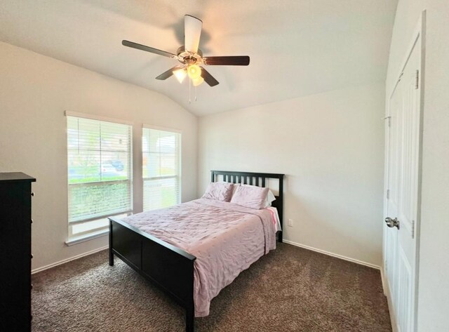 carpeted bedroom featuring ceiling fan, vaulted ceiling, and multiple windows