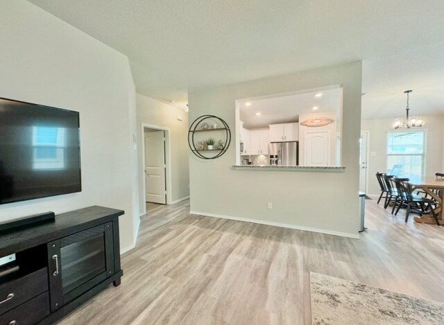 living room with a notable chandelier and light wood-type flooring