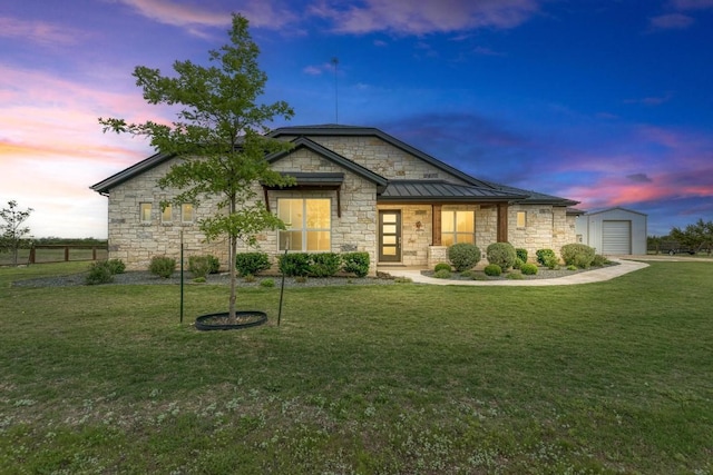 view of front of property featuring a yard, a garage, and an outdoor structure