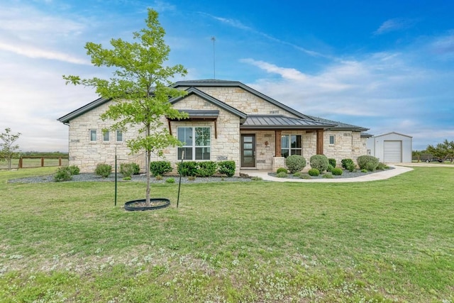 craftsman-style home featuring a front yard, an outbuilding, and a garage